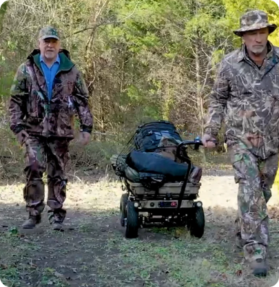 Two hunters pulling gear cart on trail