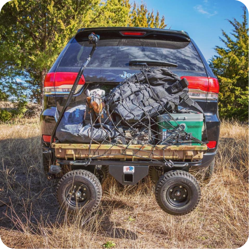Hunting gear netted on camo cart behind Jeep